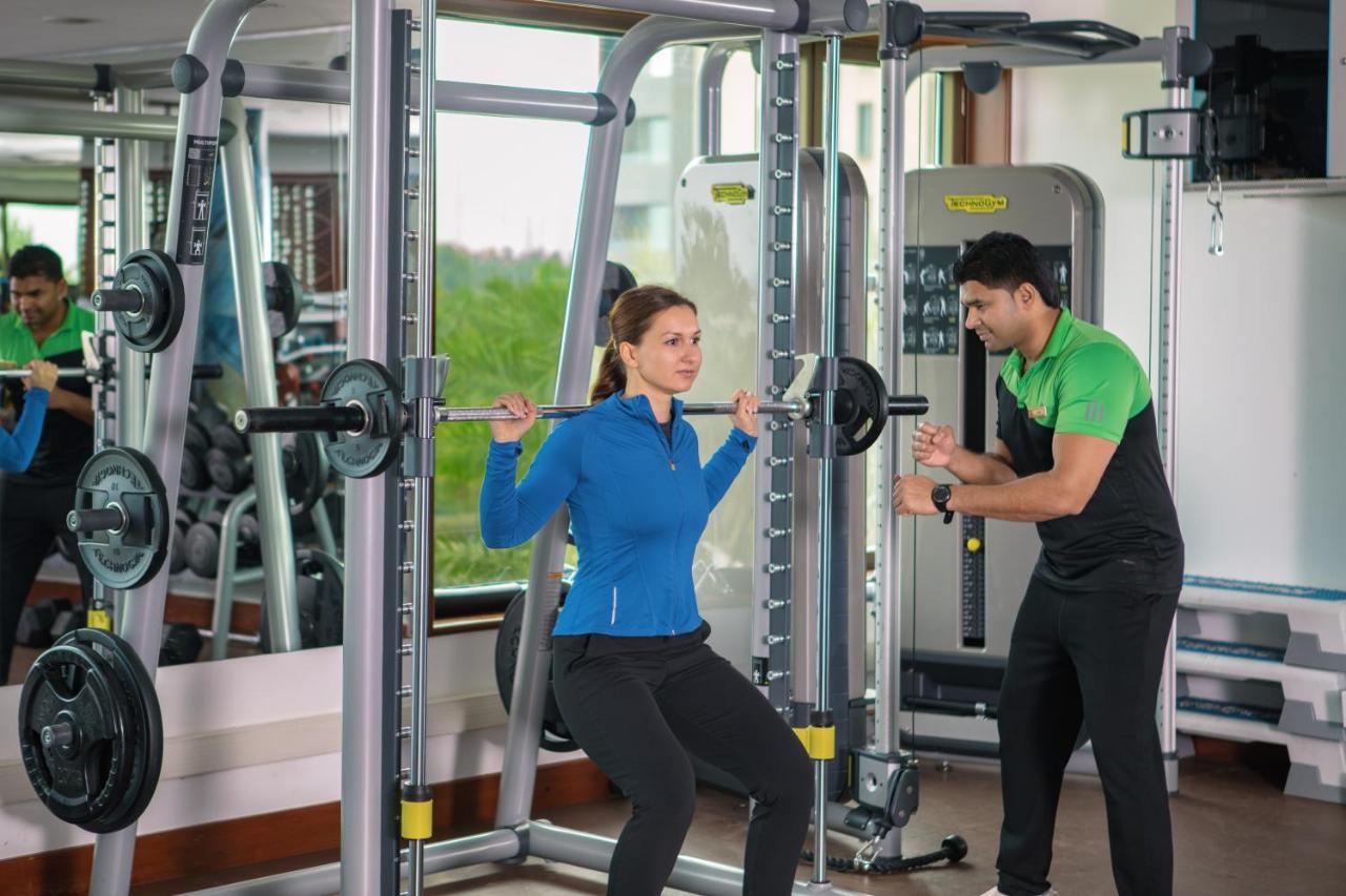 ジュメイラ メシラ ビーチ ホテル ＆ スパ クウェート エクステリア 写真 A personal trainer assisting a woman with a squat