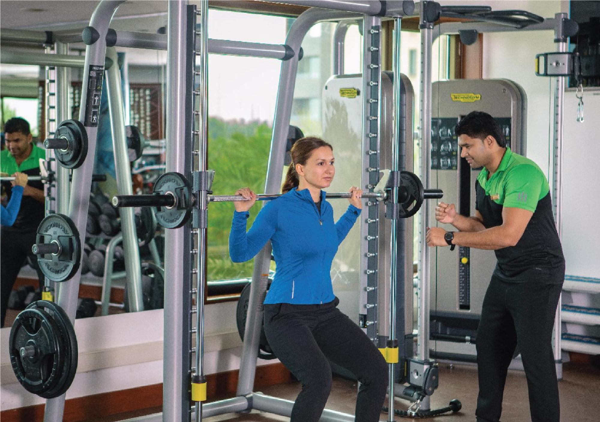 ジュメイラ メシラ ビーチ ホテル ＆ スパ クウェート エクステリア 写真 A personal trainer assisting a woman with a weight training exercise